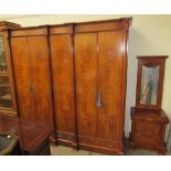 A large modern walnut wardrobe with a moulded cornice above five doors with drawers to the base on