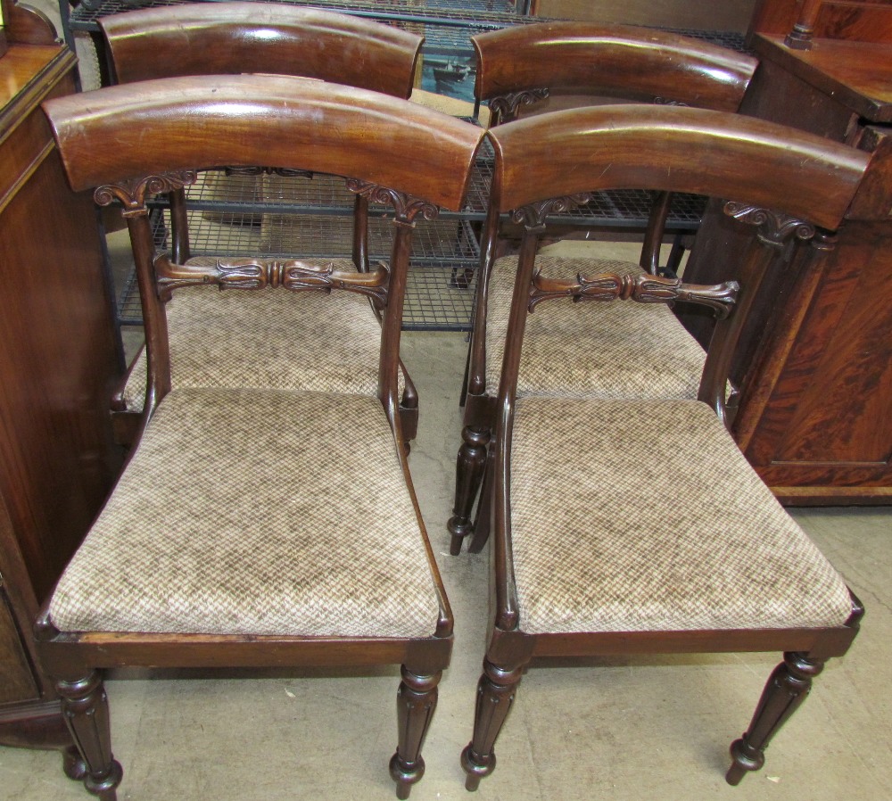 A set of four Regency mahogany dining chairs with leaf carved bar backs and drop in seats on