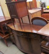 A reproduction mahogany sideboard with a shaped top together with a bedside cabinet