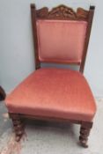 An Edwardian nursing chair with a carved back and pad back and seat