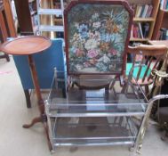 A chrome plated and smoked glass tea trolley together with a fire screen with woolwork panel and a