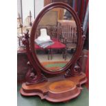 A Victorian mahogany toilet mirror with an oval mirror between carved uprights,