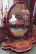 A Victorian mahogany toilet mirror with an oval mirror between carved uprights,