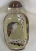 A glass snuff bottle decorated with an egret to one side and another bird to the other