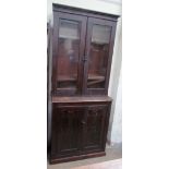 An Edwardian stained pine bookcase with a glazed top and cupboard base