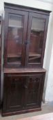 An Edwardian stained pine bookcase with a glazed top and cupboard base