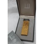 A Dunhill gold plated lighter with a bark texture,
