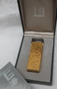 A Dunhill gold plated lighter with a bark texture,