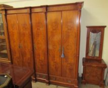 A large modern walnut wardrobe with a moulded cornice above five doors with drawers to the base on