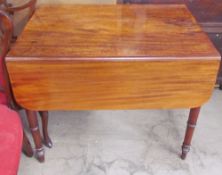 A Victorian mahogany Pembroke table with a rectangular top and drop flaps on ring turned tapering