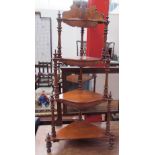 A Victorian walnut four tier whatnot with marquetry decoration and spindle uprights