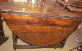 A 19th century oak gate leg dining table with an oval planked top on tapering legs