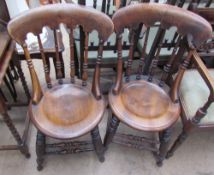 A pair of kitchen dining chairs with circular seats and spindle backs together with a pair of brass