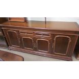 A 20th century mahogany sideboard with a central drawer and four cupboard doors on turned feet,