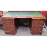 A Victorian mahogany desk with a leather inset top above two banks of drawers on a plinth base and