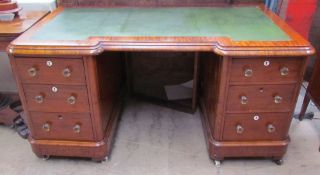 A Victorian mahogany desk with a leather inset top above two banks of drawers on a plinth base and