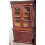 A Victorian mahogany bookcase with a moulded cornice above a pair of glazed doors,