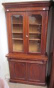 A Victorian mahogany bookcase with a moulded cornice above a pair of glazed doors,