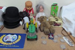 A Rosebud doll together with other dolls, a teddy bear, model cars, a model tractor, coins,