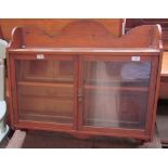 A pine hanging wall cupboard with an arched back and a pair of glazed doors