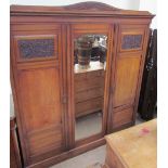 An Edwardian oak triple wardrobe with a central mirrored door and two doors either side