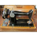 A Singer sewing machine in a domed oak case