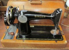 A Singer sewing machine in a domed oak case