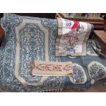 A crewel work rug with a blue ground together with a blanket and silkworm panels