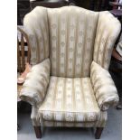 A George III style upholstered wing back elbow chair on square legs