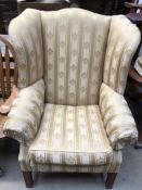 A George III style upholstered wing back elbow chair on square legs
