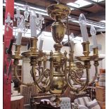 A brass five branch chandelier with scrolling arms