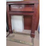 A 20th century mahogany fire surround with scrolling decoration together with two brass fire