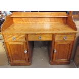 A satin walnut desk, with a raised back and shelf above a central drawer,