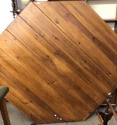 A large octagonal pine dining table on a panelled base,