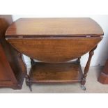 A 20th century oak tea trolley with oval drop flaps,