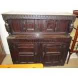 An 18th century oak court cupboard, the planked top above a carved frieze and turned columns,