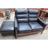 A black leather upholstered two seater settee together with a footstool