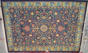 A large rug with a blue ground and scrolling flowers