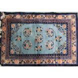 A rug with a light blue ground and circular floral medallions with geometric and floral borders