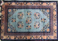 A rug with a light blue ground and circular floral medallions with geometric and floral borders