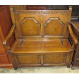 A 20th century oak box settle with a two panel back,