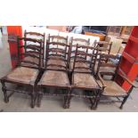 A set of seven ladder back dining chairs with rush seats together with a similar elbow chair