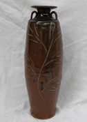 A studio pottery twin handled vase, with a brown ground and incised leaf and floral decoration,