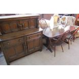 An Ercol dark oak dining suite comprising a dining table,