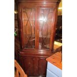 A reproduction mahogany standing corner cupboard with an astragal glazed top and cupboard base