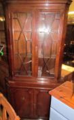 A reproduction mahogany standing corner cupboard with an astragal glazed top and cupboard base