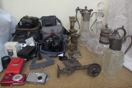 A Nikon Coolpix 8700 camera together with a collection of cameras, brass candlesticks, claret jugs,