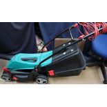 A Bosch electric lawn mower together with another lawn mower and other tools
