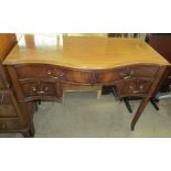 An early 20th century mahogany dressing table of serpentine outline with four drawers about a knee