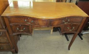 An early 20th century mahogany dressing table of serpentine outline with four drawers about a knee